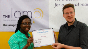 Education Department Staff Zenzele Johnson and Alan Berry hold the certificate of completion for the Outcomes and Measurement program.