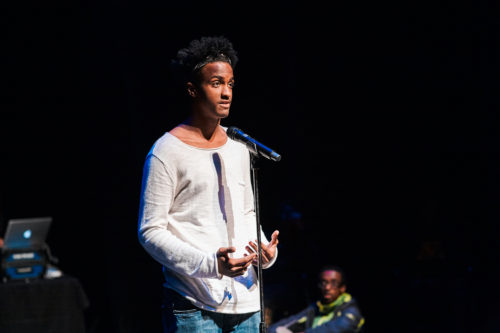 A student performs an original poem at the Guthrie Theater.